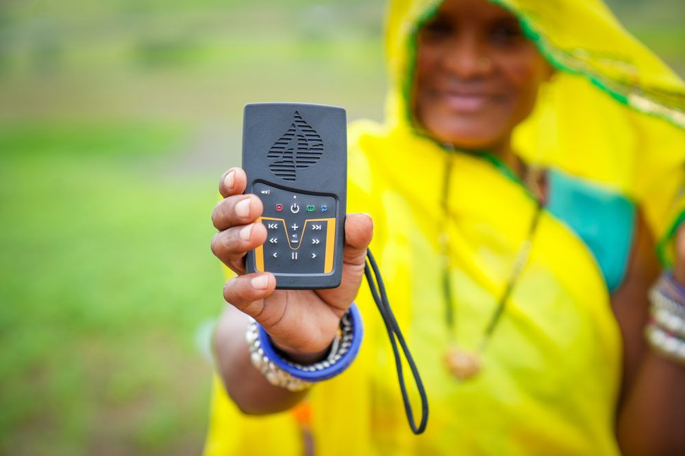 A woman holding out the WCOI Audio Bible device